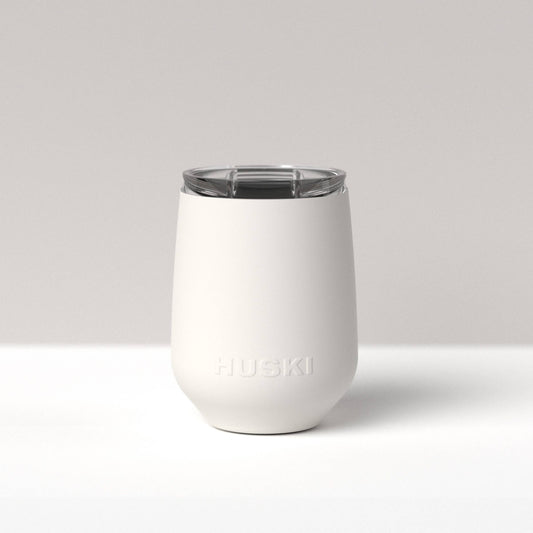 White insulated tumbler with clear lid on a light gray background