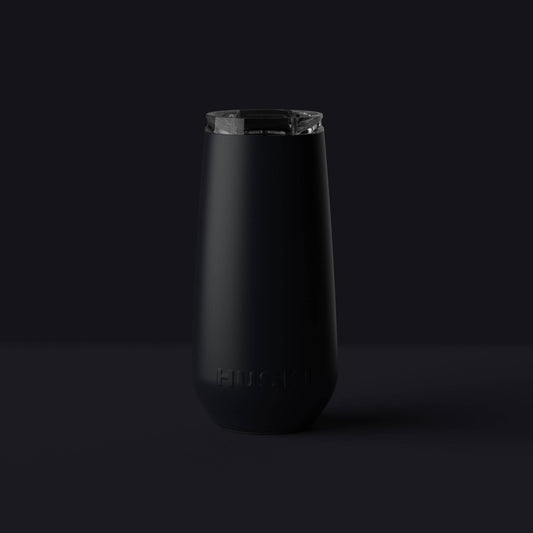 Black tumbler with a clear lid on a black background